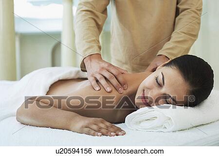 Stock Photograph - Young woman lying down and being massaged portrait. Fotosearch