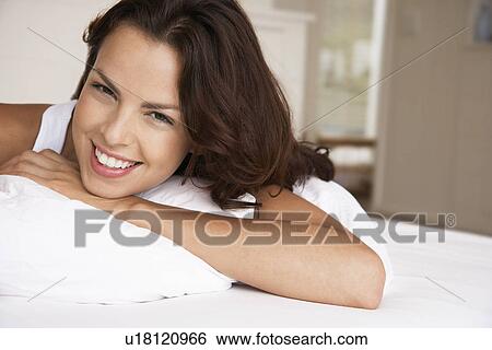 Young woman lying in bed head and shoulders View Large Photo Image Stock Photograph - Young woman lying in bed head and shoulders. Fotosearch