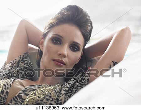 Young woman reclining on couch indoors close-up portrait View Large Photo Image Stock Image - Young woman reclining on couch indoors close-up portrait. Fotosearch