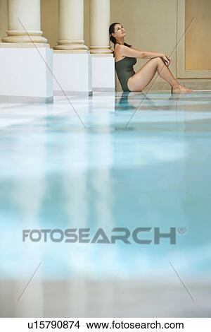 Young woman sitting by swimming pool portrait side view View Large Photo Image Picture - Young woman sitting by swimming pool portrait side view. Fotosearch