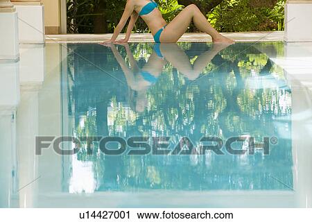 Young woman sitting by swimming pool side view low section View Large Photo Image Stock Image - Young woman sitting by swimming pool side view low section. Fotosearch