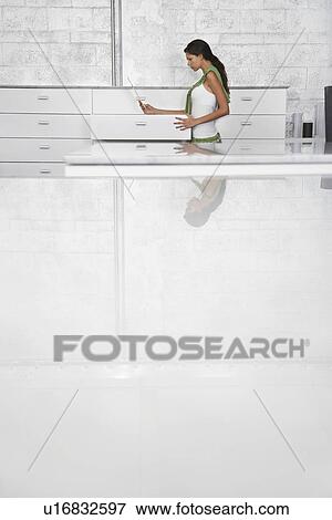 Young woman standing by drawer profile View Large Photo Image Stock Photo - Young woman standing by drawer profile. Fotosearch
