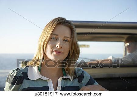 Young woman standing by van head and shoulder man in van View Large Photo Image Stock Photo - Young woman standing by van head and shoulder man in van. Fotosearch