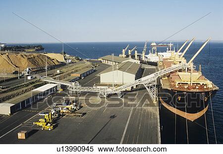 Stock Photography - Aerial view wood chips loading onto ship Victoria Australia. Fotosearch