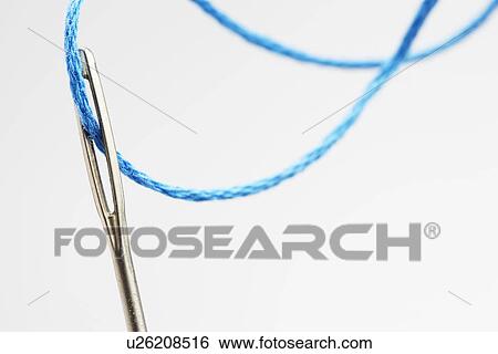 Blue thread going through needle eye close-up View Large Photo Image Stock Photograph - Blue thread going through needle eye close-up. Fotosearch