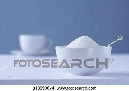 Bowl of sugar on table tea cup in background View Large Photo Image Picture - Bowl of sugar on table tea cup in background. Fotosearch