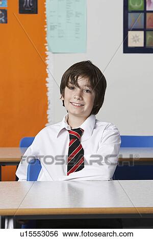 Boy (10-12) wearing shirt and tie in classroom View Large Photo Image Stock Photograph - Boy (10-12) wearing shirt and tie in classroom. Fotosearch