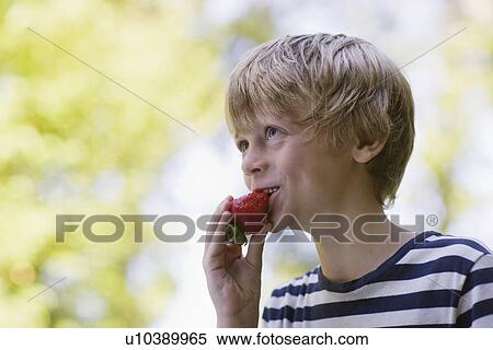 Boy (5-6) eating strawberry smiling View Large Photo Image Stock Photography - Boy (5-6) eating strawberry smiling. Fotosearch