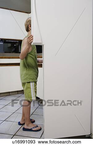 Boy (5-6) looking into fridge View Large Photo Image Stock Image - Boy (5-6) looking into fridge. Fotosearch