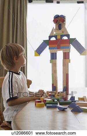 Boy (5-6) playing with building blocks at table View Large Photo Image Stock Image - Boy (5-6) playing with building blocks at table. Fotosearch