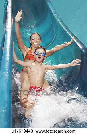 Brother and sister (7-12) with arms outstretched on water slide View Large Photo Image Stock Photo - Brother and sister (7-12) with arms outstretched on water slide. Fotosearch