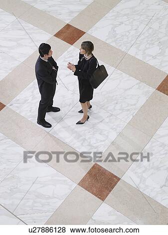 Business man and business woman talking elevated view View Large Photo Image Stock Photo - Business man and business woman talking elevated view. Fotosearch