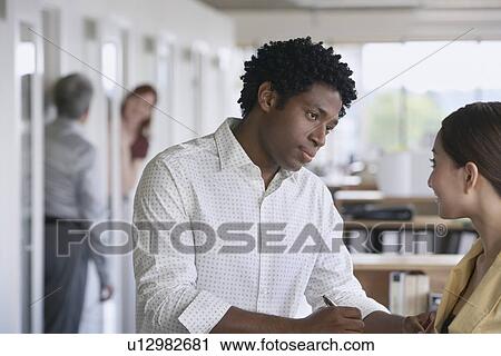 Business man and colleague talking in office View Large Photo Image Stock Image - Business man and colleague talking in office. Fotosearch