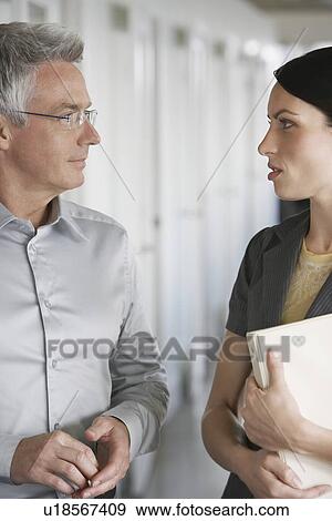 Business man and female colleague talking in office View Large Photo Image Stock Photo - Business man and female colleague talking in office. Fotosearch