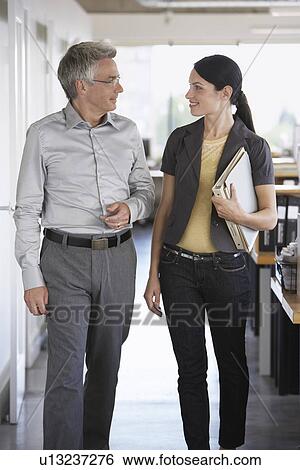 Business man and female colleague talking in office View Large Photo Image Stock Photograph - Business man and female colleague talking in office. Fotosearch
