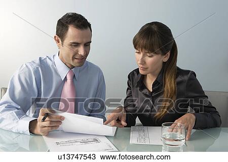 Business man and woman working at table in office View Large Photo Image Stock Image - Business man and woman working at table in office. Fotosearch