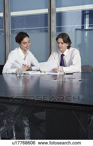 Business man and woman working at table in conference room View Large Photo Image Stock Photograph - Business man and woman working at table in conference room. Fotosearch