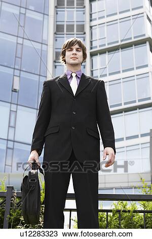Business man holding briefcase outside office portrait View Large Photo Image Stock Image - Business man holding briefcase outside office portrait. Fotosearch