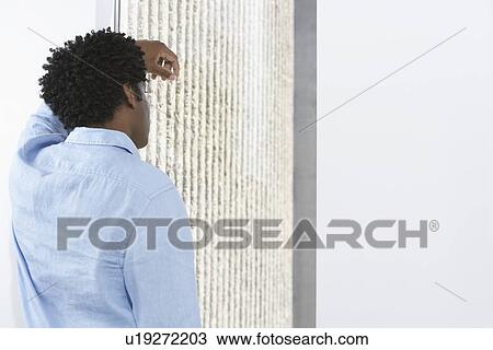 Business man leaning against wall indoors View Large Photo Image Stock Image - Business man leaning against wall indoors. Fotosearch