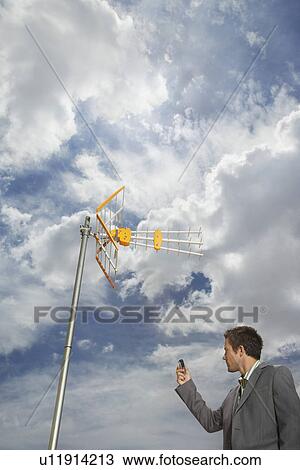 Business man pointing cell phone at aerial View Large Photo Image Stock Image - Business man pointing cell phone at aerial. Fotosearch