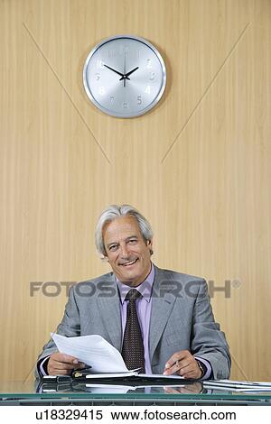 Business man reading papers in office View Large Photo Image Stock Photography - Business man reading papers in office. Fotosearch