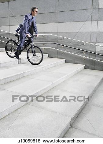 Business man riding bicycle down steps side view View Large Photo Image Stock Photo - Business man riding bicycle down steps side view. Fotosearch