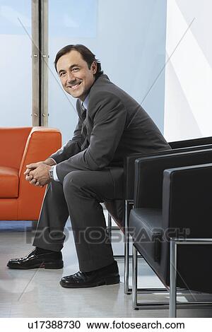 Business man sitting in leather chair in office portrait View Large Photo Image Stock Image - Business man sitting in leather chair in office portrait. Fotosearch