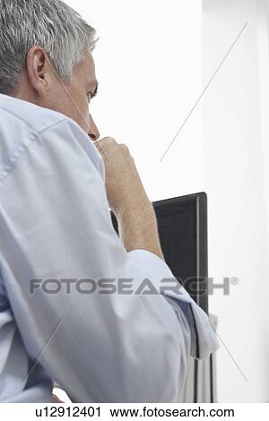Business man sitting in office over the shoulder view View Large Photo Image Stock Image - Business man sitting in office over the shoulder view. Fotosearch