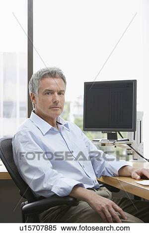Stock Photography - Business man sitting in office portrait. Fotosearch