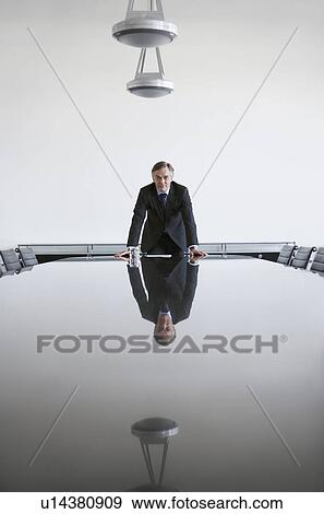 Stock Photo - Business man standing at conference table. Fotosearch