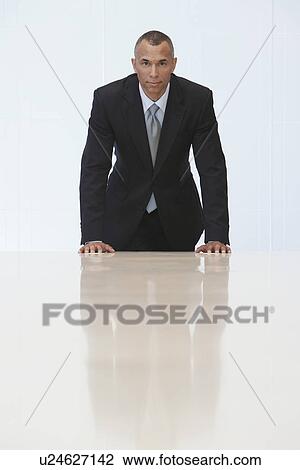 Business man standing at end of conference table portrait View Large Photo Image Stock Image - Business man standing at end of conference table portrait. Fotosearch