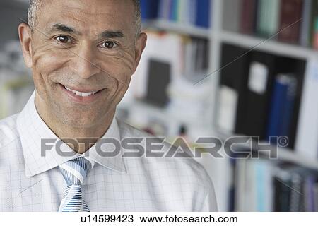Stock Image - Business man standing in office elevated view portrait. Fotosearch