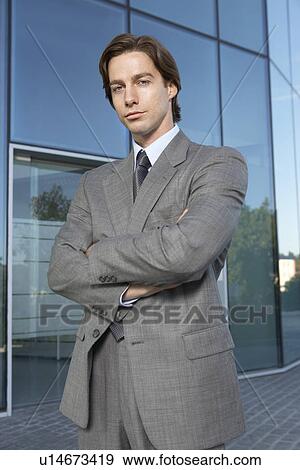 Business man standing outside office building portrait View Large Photo Image Stock Photo - Business man standing outside office building portrait. Fotosearch