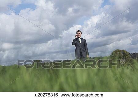 Business man talking on mobile phone in field selective focus View Large Photo Image Stock Photograph - Business man talking on mobile phone in field selective focus. Fotosearch