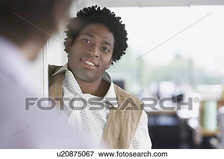 Stock Photo - Business man talking to colleague in office. Fotosearch