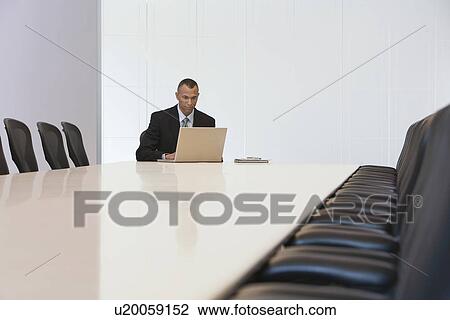 Business man using laptop in board room View Large Photo Image Stock Image - Business man using laptop in board room. Fotosearch