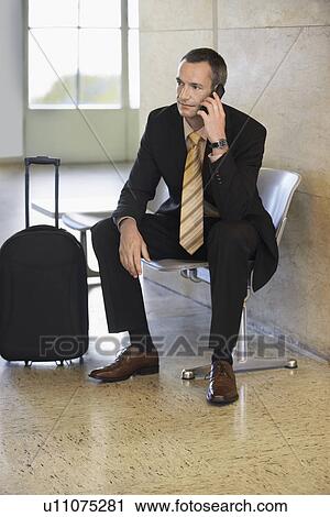 Business man using mobile phone in airport View Large Photo Image Stock Image - Business man using mobile phone in airport. Fotosearch