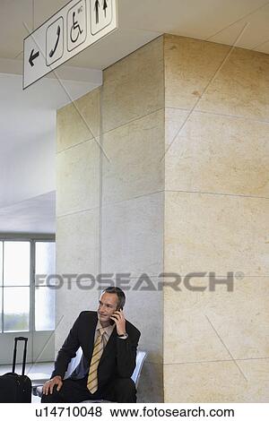 Business man using mobile phone in airport View Large Photo Image Stock Photo - Business man using mobile phone in airport. Fotosearch