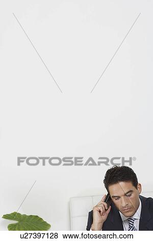 Business man using mobile phone in white office View Large Photo Image Stock Photo - Business man using mobile phone in white office. Fotosearch
