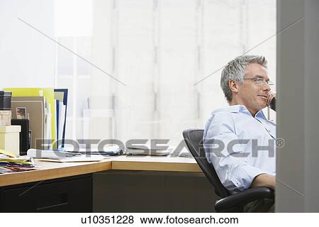 Business man using phone in office View Large Photo Image Stock Photo - Business man using phone in office. Fotosearch