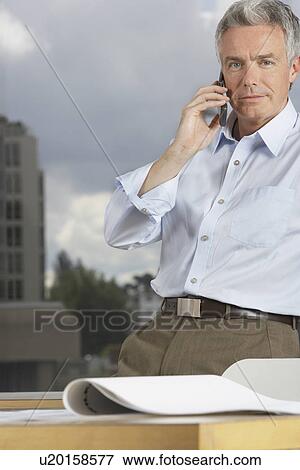 Business man using phone in office View Large Photo Image Stock Photo - Business man using phone in office. Fotosearch