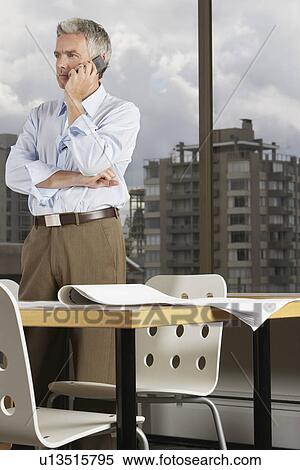 Business man using phone in office View Large Photo Image Stock Photography - Business man using phone in office. Fotosearch