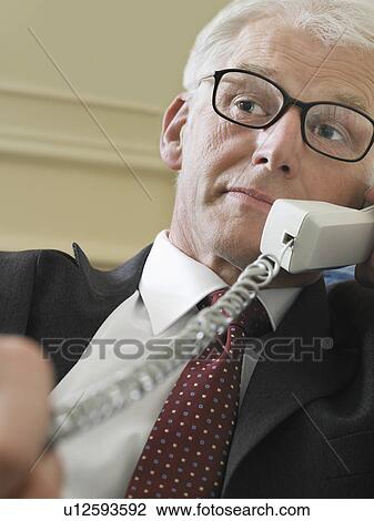 Business man using phone sitting on sofa close-up low angle view View Large Photo Image Stock Image - Business man using phone sitting on sofa close-up low angle view. Fotosearch