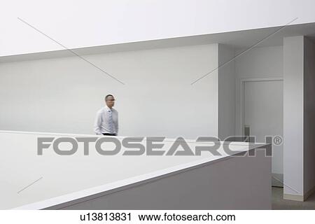 Business man walking through office hallway side view View Large Photo Image Stock Image - Business man walking through office hallway side view. Fotosearch