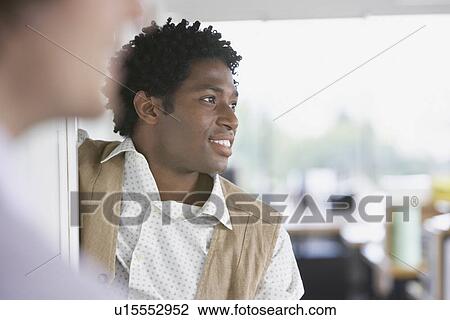 Stock Image - Business man with colleague in office. Fotosearch