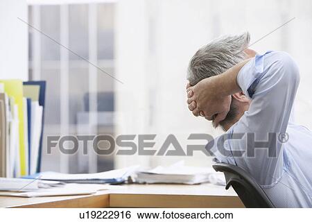 Business man with hands behind head in office View Large Photo Image Stock Photograph - Business man with hands behind head in office. Fotosearch