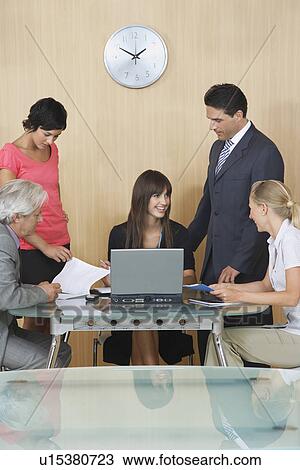 Stock Image - Business people having meeting in conference room. Fotosearch