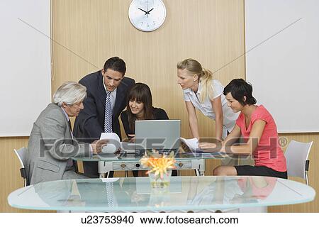 Stock Image - Business people having meeting in conference room. Fotosearch