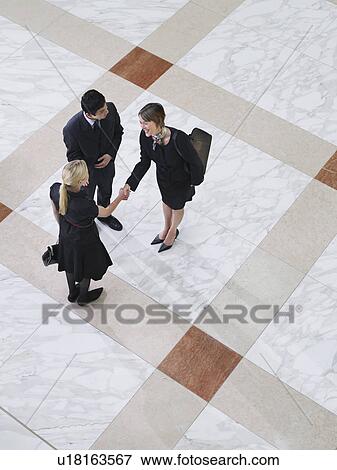 Business people shaking hands elevated view View Large Photo Image Stock Photo - Business people shaking hands elevated view. Fotosearch