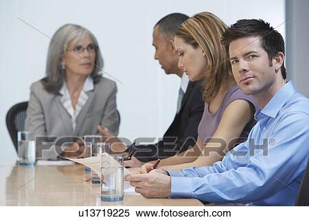 Stock Photography - Business people sitting at conference table. Fotosearch